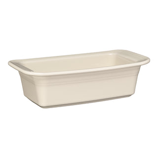 The Fiesta 10 3/4 x 5 3/4 Inch Loaf Pan Baker (1.4 Quarts) in Linen features slightly flared sides and rounded corners, is ceramic, dishwasher safe, made in the USA, and appears on a white background.