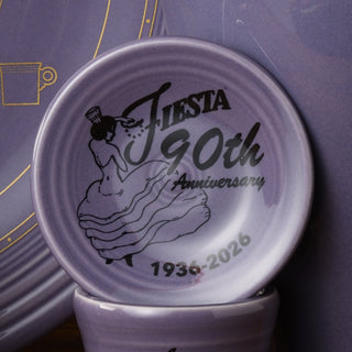 The Fiesta Lavender 90th Anniversary 3 Inch Mini Magnet Dinner Plate by Fiesta features 1936-2026 and a woman in a dress holding a plate, all in black on collectible lavender dinnerware.