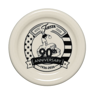 Cream-colored Fiesta Linen 90th Anniversary 4 3/8 Inch Coaster and Mug Cover with black design—woman, stars and stripes, 90th Anniversary 1936-2026. Limited edition from Fiesta.
