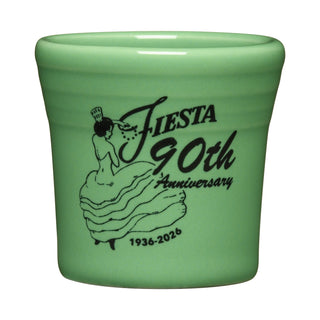The Fiesta 90th Anniversary Meadow 1 1/2 OZ Ceramic Shot Glass features a green glaze, a woman in a dress illustration, and the text: Fiesta 90th Anniversary 1936-2026—a limited edition collectible.