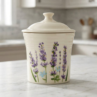Cream-colored ceramic Lavender Bloom 13 OZ Mini Canister 5 5/8 Inch with a lid, decorated with a painted pattern of lavender sprigs.