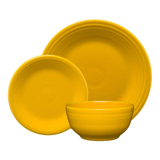 The Fiesta Daffodil Classic Bistro 3-Piece Place Setting, Service for 1, includes a large plate, salad plate, and cereal bowl in bright yellow with a simple ridged design, all displayed on a white background.