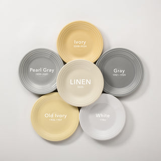 Six plates in a circular arrangement display different shades and names: Pearl Gray (1999-2001), Ivory (2008-2024), Gray (1951-1959), White (1986), Old Ivory (1936-1969), and Linen (2025) at the center.