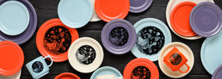 Colorful plates and mugs with various designs on a dark surface