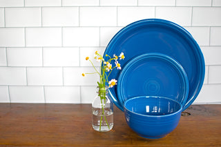 lapis place setting. Next to place setting is clear jar with daisies