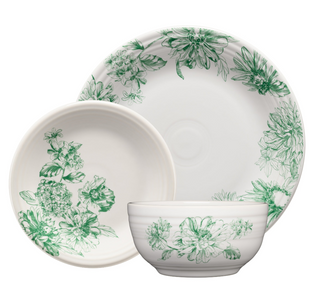The Fiesta Botanical Floral Jade Classic Rim 7 1/4 Inch Salad Plate features green botanical floral patterns along the edges and is shown overlapping a white dinner plate and bowl against a white background.