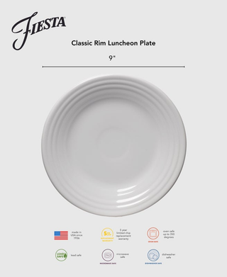 A Botanical Floral Lavender Classic Rim 9 Inch Luncheon Plate by Fiesta, made of ceramic, is shown on a grey background. Icons indicate it's microwave, oven, and dishwasher safe, lead free, USA-made, with a 5-year chip warranty.
